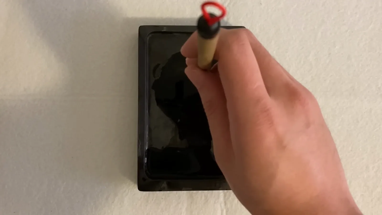 A Chinese calligraphy brush held perfectly vertical above an inkstone, the upright posture check to make before writing any stroke A Chinese calligraphy brush held perfectly vertical above an inkstone, the upright posture check to make before writing any stroke