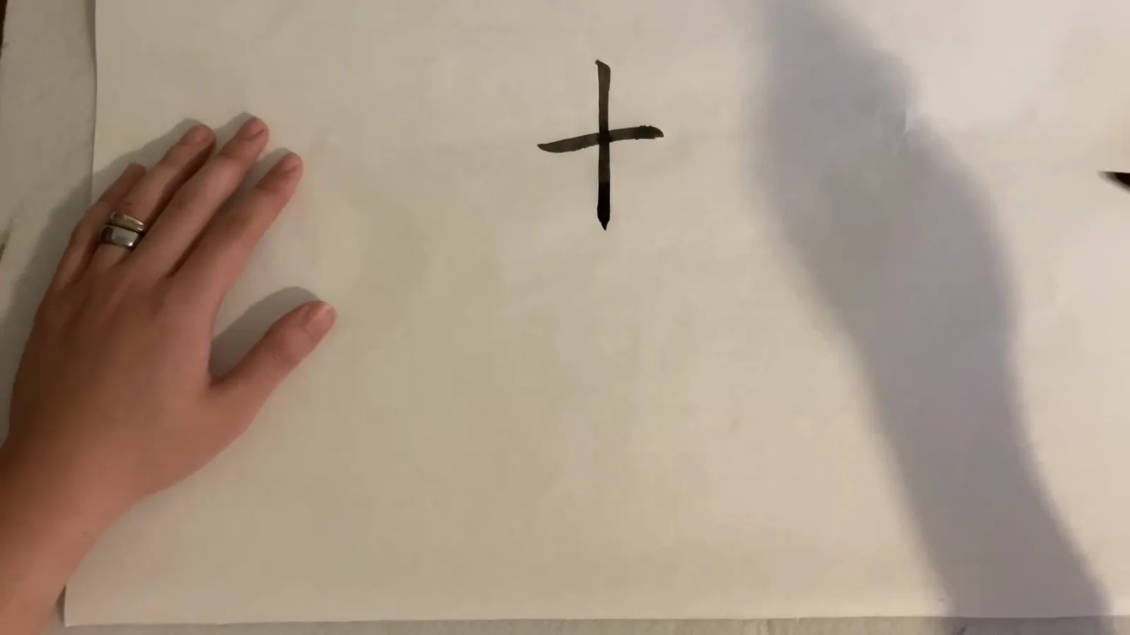 The Chinese character shi meaning ten completed on practice paper as a cross of one horizontal and one vertical calligraphy brush stroke The Chinese character shi meaning ten completed on practice paper as a cross of one horizontal and one vertical calligraphy brush stroke