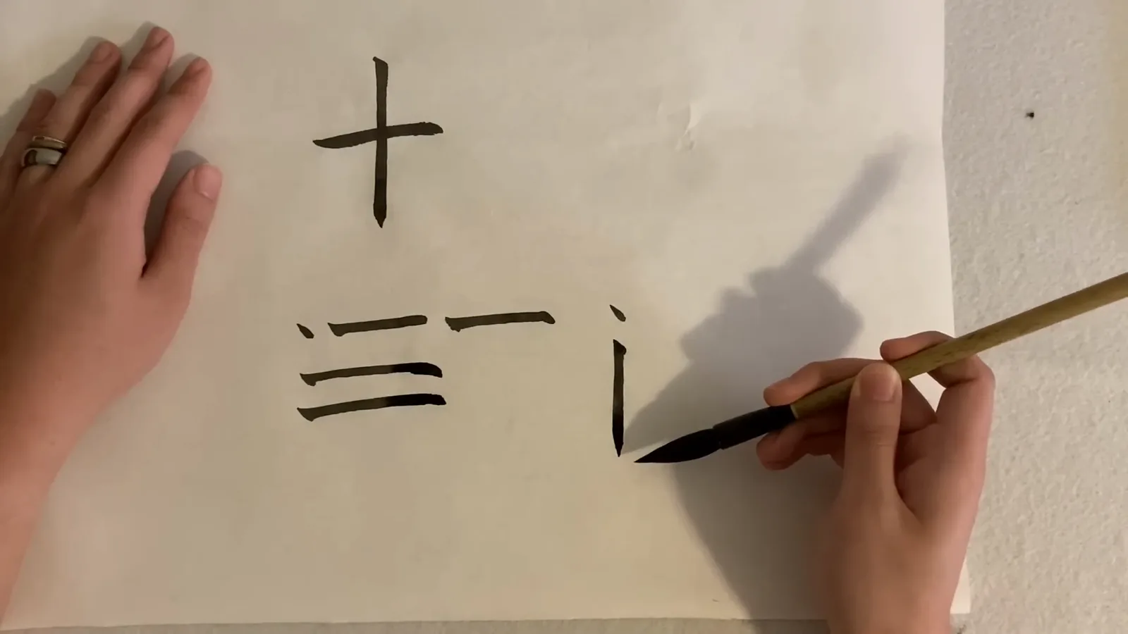 A vertical shu brush stroke tapering to a sharp hanging-needle tip as the brush is lifted slowly at the end of the movement on rice paper A vertical shu brush stroke tapering to a sharp hanging-needle tip as the brush is lifted slowly at the end of the movement on rice paper