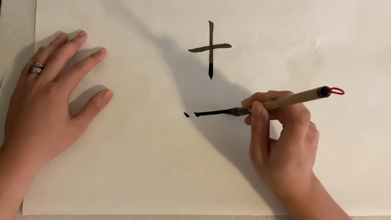 A Chinese calligraphy brush mid-stroke drawing a horizontal line whose landing, dragging and finishing phases control the pressure along the stroke A Chinese calligraphy brush mid-stroke drawing a horizontal line whose landing, dragging and finishing phases control the pressure along the stroke